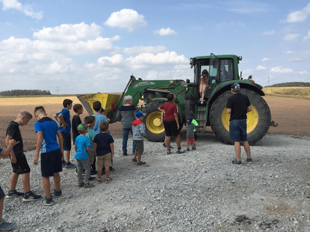Kinder auf Traktor beim Ferienprogramm